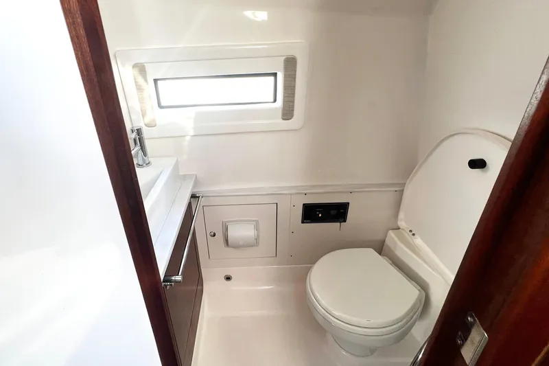 Slide: The Image of 2023 Pursuit S 378 Sport boat bathroom with toilet, sink, and window. - 65