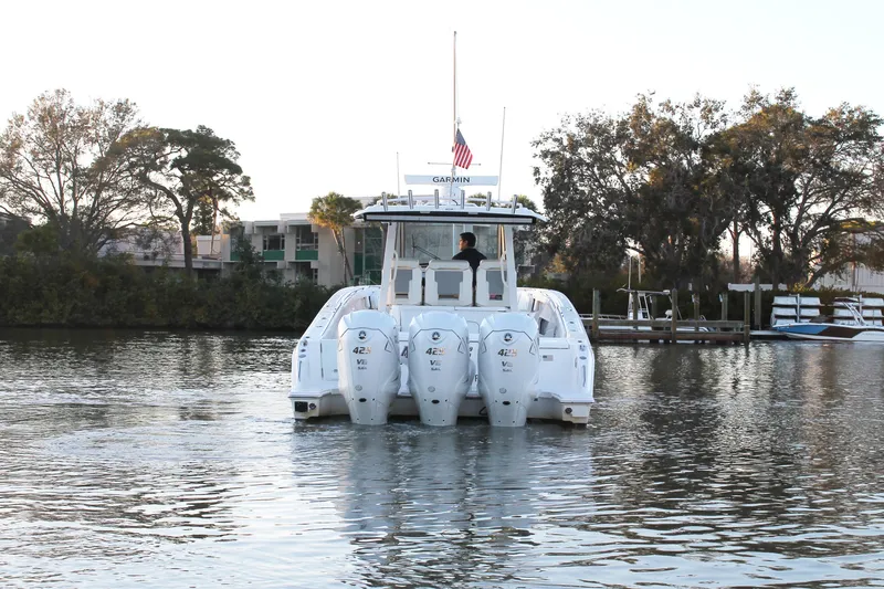 Slide: The Image of 2023 Pursuit S 378 Sport boat with triple engines on a calm river. - 7