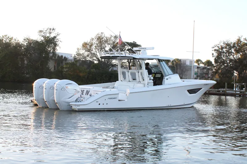 Slide: The Image of 2023 Pursuit S 378 Sport boat on calm water, featuring triple outboard engines. - 9