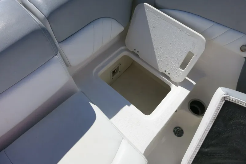 Slide: The Image of 2019 Chaparral 21 H2O Sport OB boat seat storage compartment open. - 14