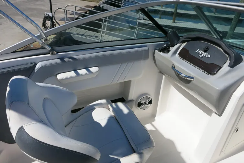 Slide: The Image of 2019 Chaparral 21 H2O Sport OB boat interior with steering console and seating. - 17