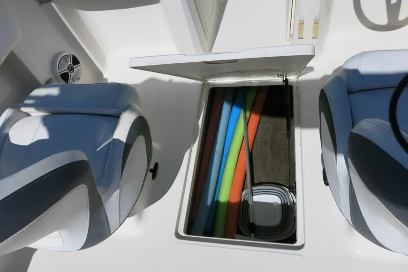 Slide: The Image of 2019 Chaparral 21 H2O Sport OB boat interior with open storage compartment and colorful pool noodles. - 18
