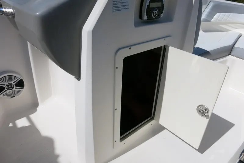Slide: The Image of 2019 Chaparral 21 H2O Sport OB boat storage compartment with open door. - 19