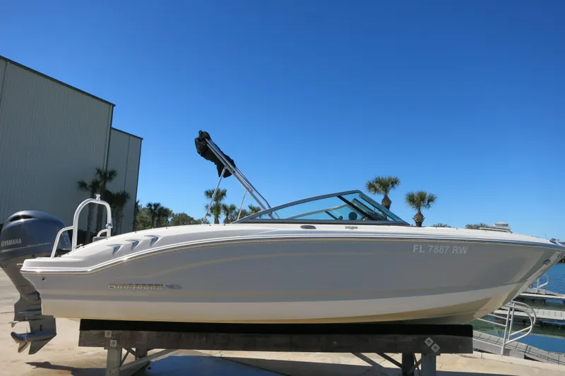 Slide: The Image of 2019 Chaparral 21 H2O Sport OB boat on display under clear blue sky. - 2