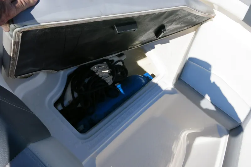 Slide: The Image of 2019 Chaparral 21 H2O Sport OB boat storage compartment with ropes and equipment. - 21