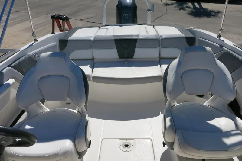 Slide: The Image of 2019 Chaparral 21 H2O Sport OB boat interior with white seating and steering wheel. - 25