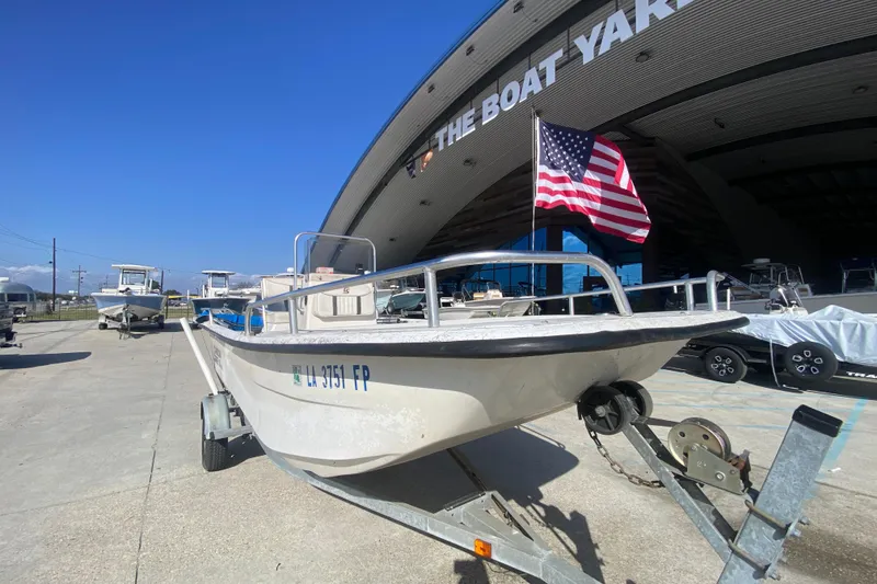 Slide: The Image of 2007 Carolina Skiff 1780 DLX boat on trailer, American flag, outside The Boat Yard. - 10