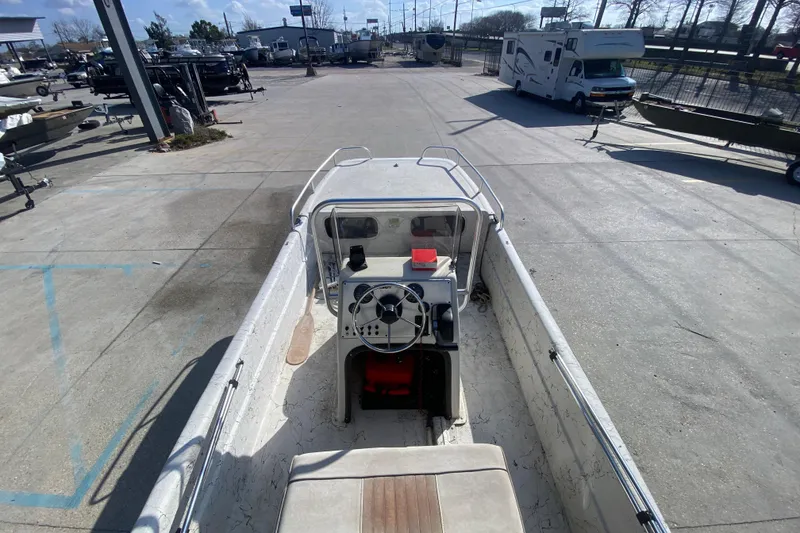 Slide: The Image of 2007 Carolina Skiff 1780 DLX boat, parked in a marina, showcasing steering console. - 11