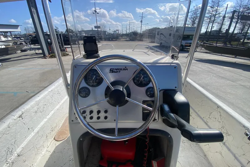 Slide: The Image of 2007 Carolina Skiff 1780 DLX boat dashboard with steering wheel and gauges. - 12