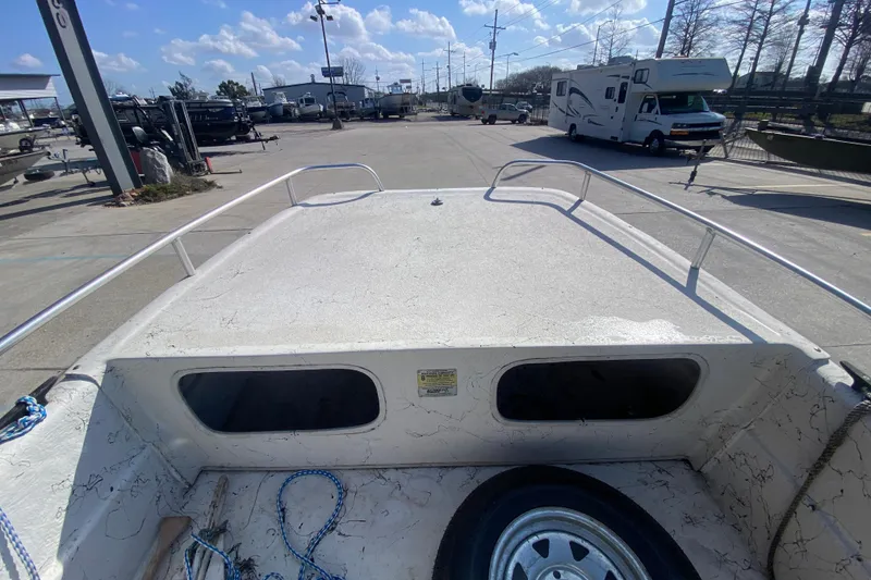 Slide: The Image of 2007 Carolina Skiff 1780 DLX boat deck with storage compartments and trailer wheel. - 13