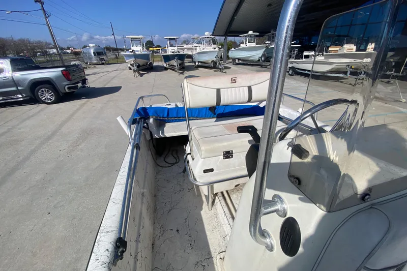 Slide: The Image of 2007 Carolina Skiff 1780 DLX boat interior at a dealership, showcasing seating and steering console. - 15