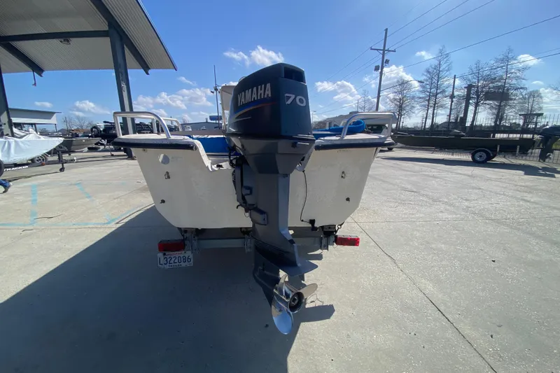 Slide: The Image of 2007 Carolina Skiff 1780 DLX with Yamaha 70 outboard motor in a sunny marina. - 5