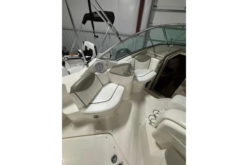 Slide: The Image of 2007 Sea Ray 240 Sundancer boat interior with white seating and cup holders. - 10