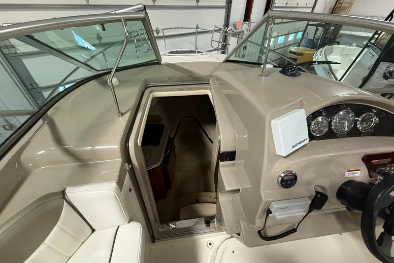 Slide: The Image of 2007 Sea Ray 240 Sundancer boat interior with helm and cabin entrance. - 13