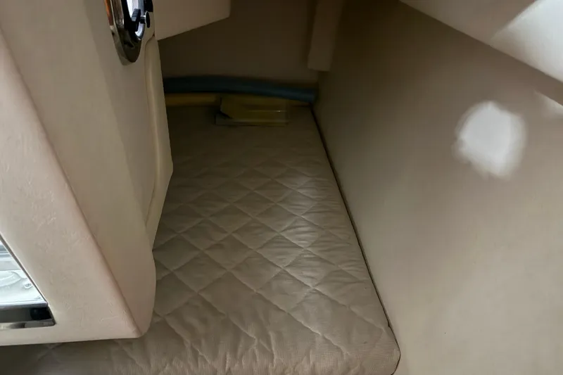 Slide: The Image of Interior cabin of 2007 Sea Ray 240 Sundancer with quilted beige upholstery. - 20