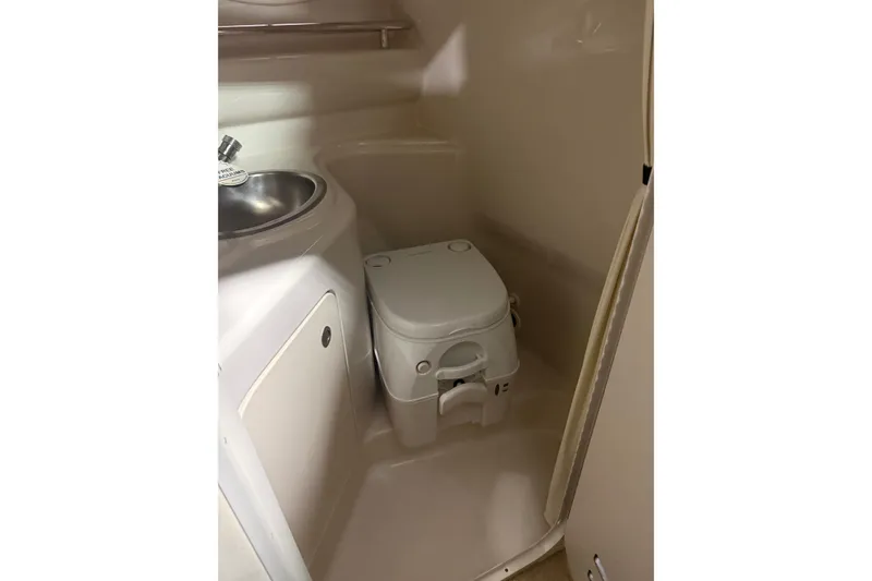 Slide: The Image of 2007 Sea Ray 240 Sundancer boat bathroom with compact toilet and sink. - 3