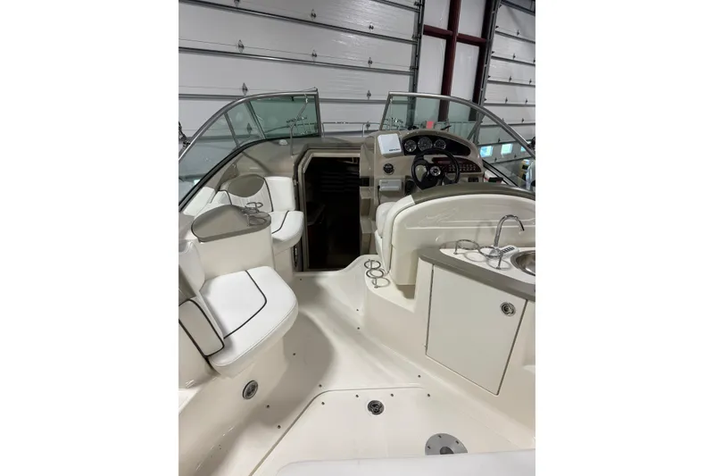 Slide: The Image of 2007 Sea Ray 240 Sundancer boat interior with helm, seating, and kitchenette. - 8