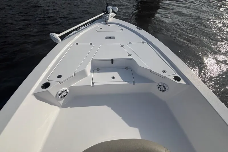 Slide: The Image of 2022 Sportsman Tournament 234 Bay Boat deck, featuring storage compartments and rod holders. - 11