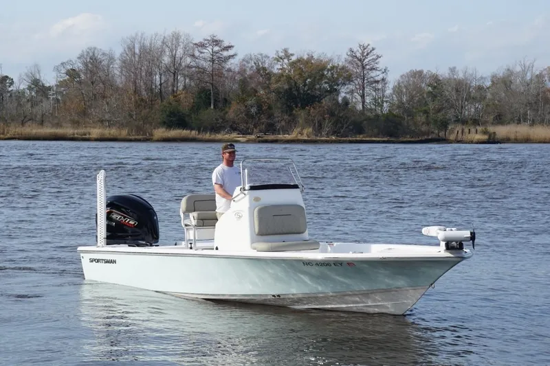 Slide: The Image of 2022 Sportsman Tournament 234 Bay Boat on calm water with driver, scenic background. - 2