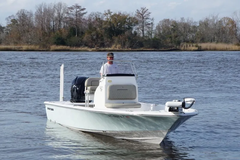 Slide: The Image of 2022 Sportsman Tournament 234 Bay Boat on calm water, with trees in the background. - 3