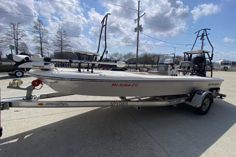 Slide: The Image of 2022 Composite Research Spyder FX-19 Vapor boat on trailer, parked outdoors under cloudy sky. - 12