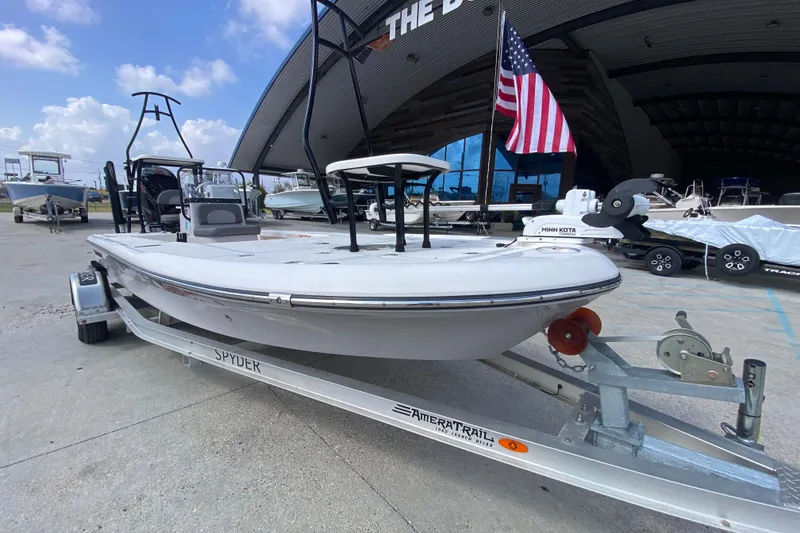 Slide: The Image of 2022 Composite Research Spyder FX-19 Vapor boat on trailer, American flag, outdoor setting. - 14