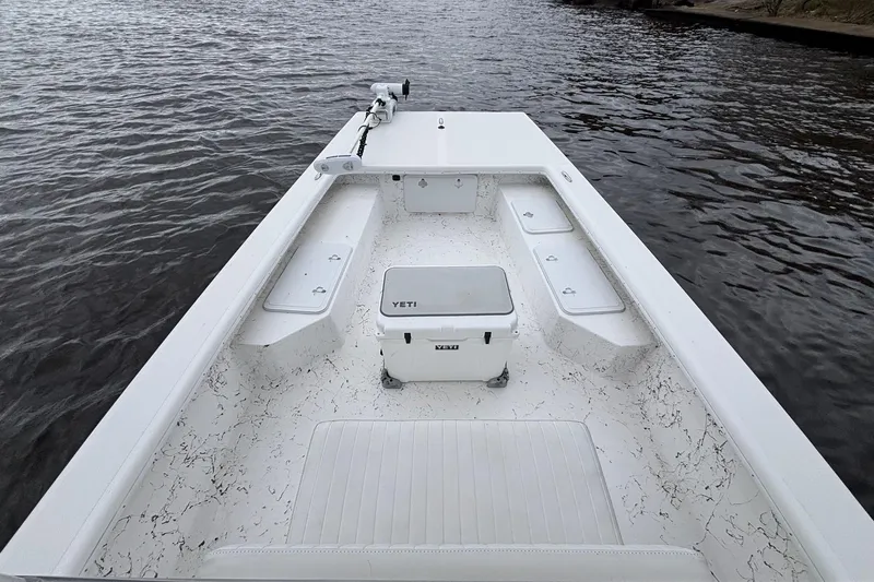 Slide: The Image of 2014 Riddick Bay Runner 2290 boat interior with Yeti cooler on calm water. - 12