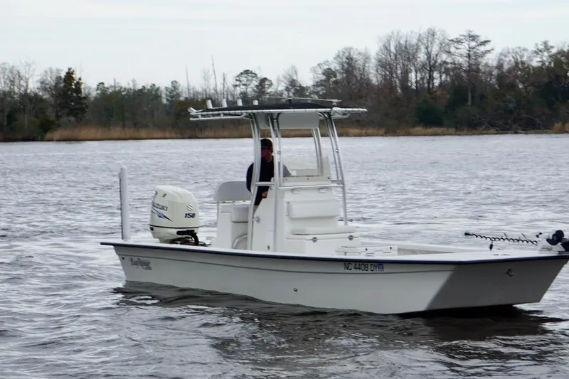 Slide: The Image of 2014 Riddick Bay Runner 2290 boat cruising on a calm river. - 7