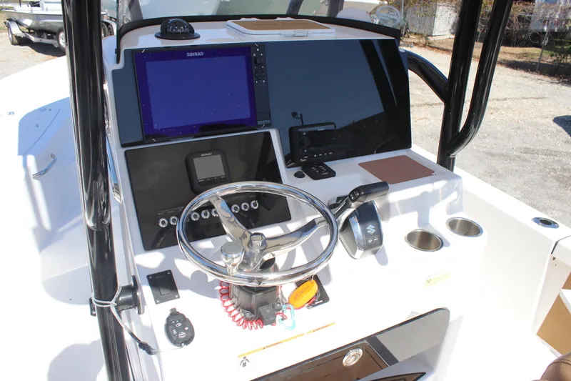 Slide: The Image of 2022 Sea Pro 248 Bay boat dashboard with steering wheel and navigation equipment. - 12