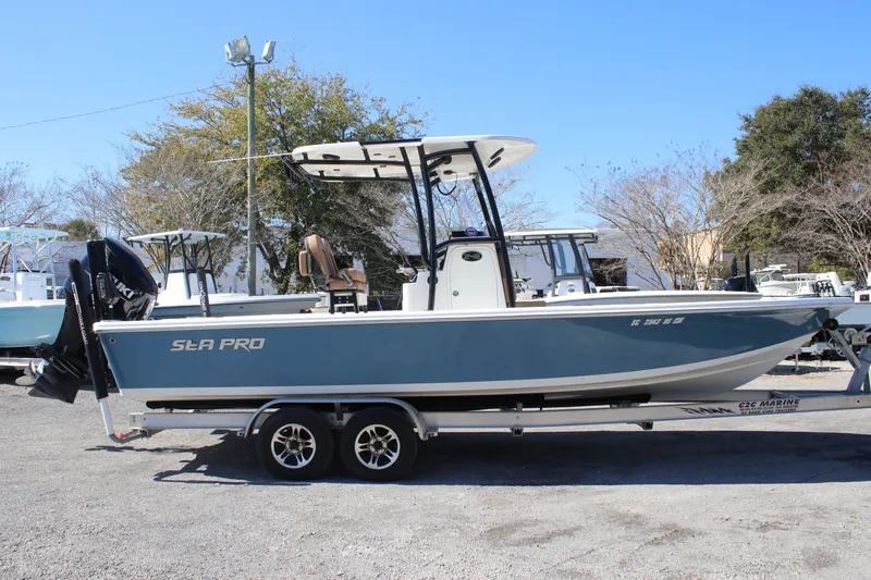 Slide: The Image of 2022 Sea Pro 248 Bay boat on trailer, parked outdoors under clear blue sky. - 4