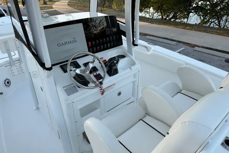 Slide: The Image of 2014 Sea Hunt Gamefish 27 boat cockpit with Garmin navigation system and white seating. - 16