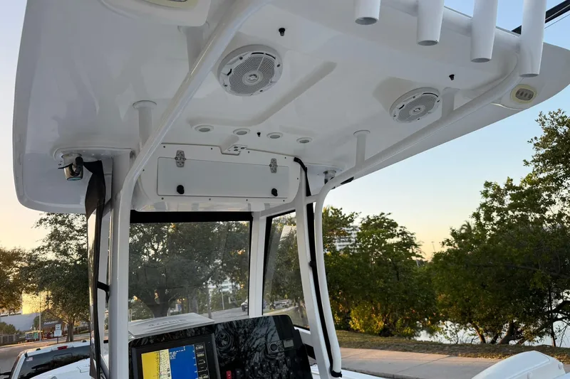 Slide: The Image of 2014 Sea Hunt Gamefish 27 boat console with electronics and rod holders, set against a scenic backdrop. - 18