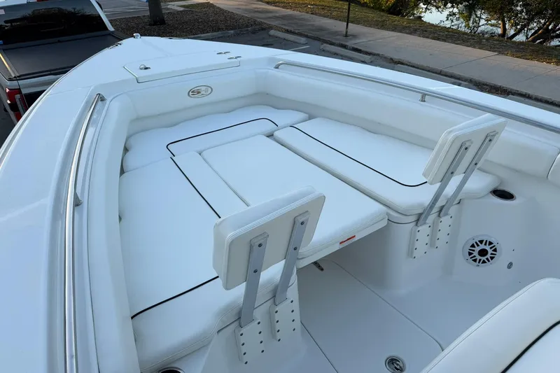 Slide: The Image of 2014 Sea Hunt Gamefish 27 boat interior with white cushioned seating and stainless steel fixtures. - 21