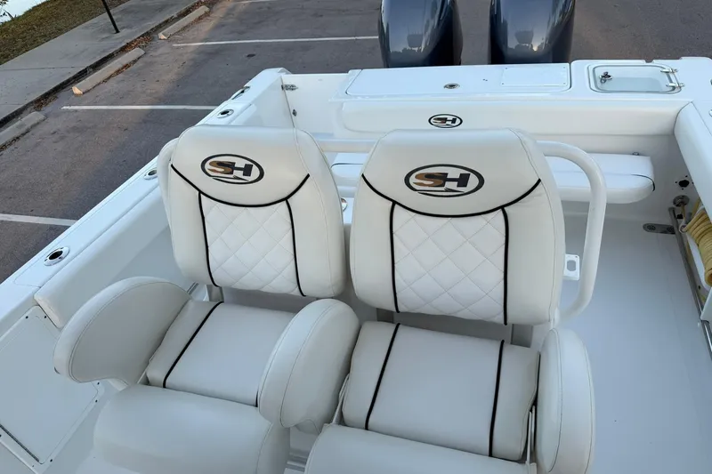 Slide: The Image of 2014 Sea Hunt Gamefish 27 boat seats with logo, featuring white upholstery and diamond stitching. - 28