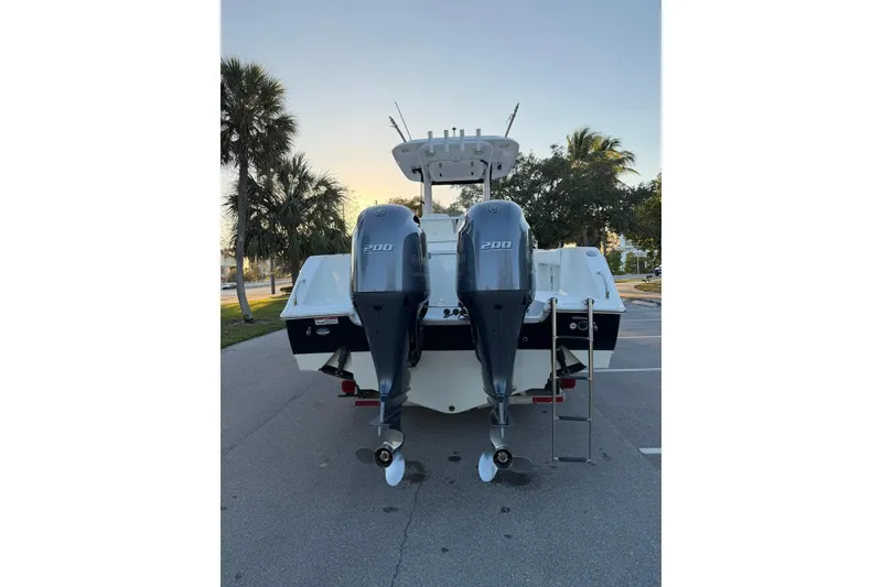 Slide: The Image of 2014 Sea Hunt Gamefish 27 boat with dual 200 horsepower engines, parked near palm trees. - 4