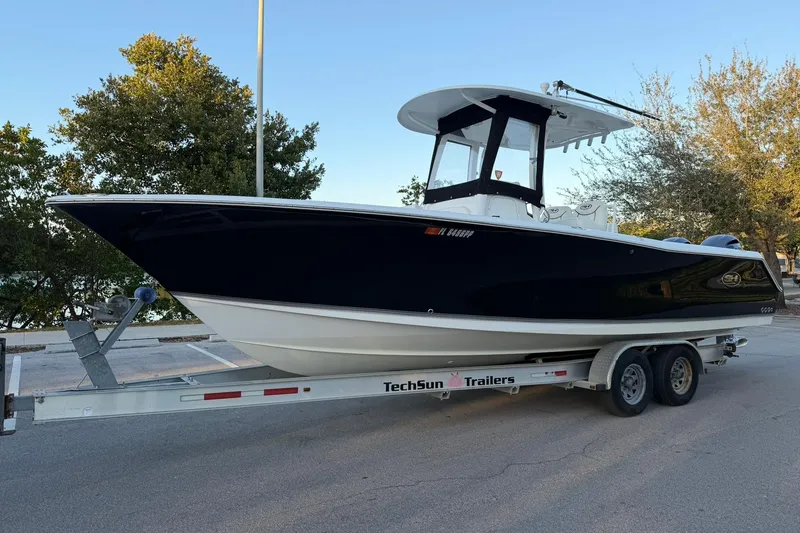 Slide: The Image of 2014 Sea Hunt Gamefish 27 boat on TechSun trailer, parked outdoors. - 7