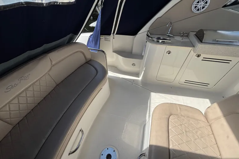 Slide: The Image of 2009 Sea Ray Sundancer 310 interior with beige seating and compact kitchenette. - 13