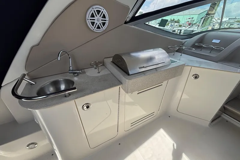 Slide: The Image of 2009 Sea Ray Sundancer 310 boat kitchenette with sink, grill, and storage cabinets. - 14