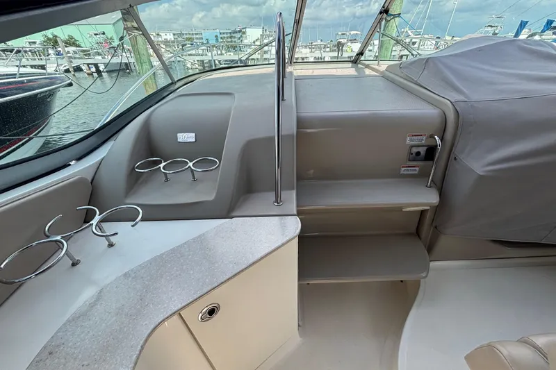Slide: The Image of 2009 Sea Ray Sundancer 310 cockpit with cup holders and covered seating area. - 16