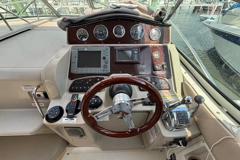 Slide: The Image of 2009 Sea Ray Sundancer 310 helm with steering wheel, gauges, and navigation controls. - 18
