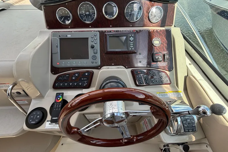 Slide: The Image of 2009 Sea Ray Sundancer 310 helm with wood accents and modern navigation controls. - 19