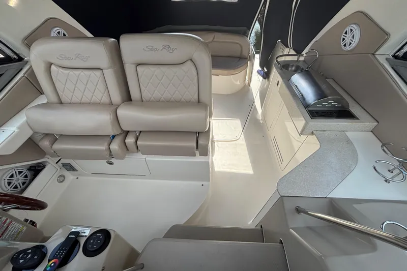 Slide: The Image of 2009 Sea Ray Sundancer 310 interior with beige seating and compact kitchenette. - 22