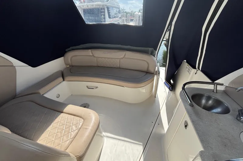 Slide: The Image of 2009 Sea Ray Sundancer 310 interior with beige seating and compact kitchenette. - 23