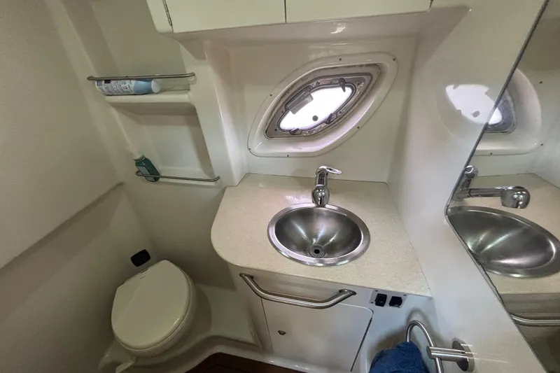 Slide: The Image of 2009 Sea Ray Sundancer 310 bathroom with sink, toilet, and porthole window. - 26
