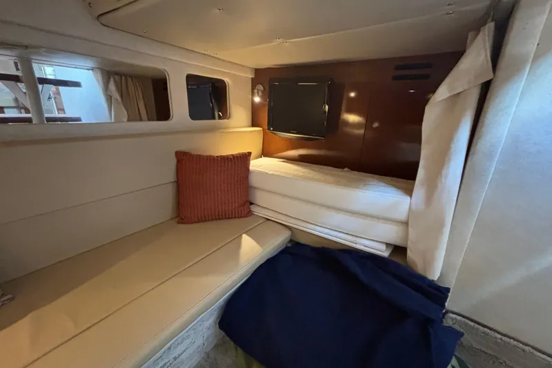 Slide: The Image of 2009 Sea Ray Sundancer 310 cabin interior with seating, bed, and TV. - 31