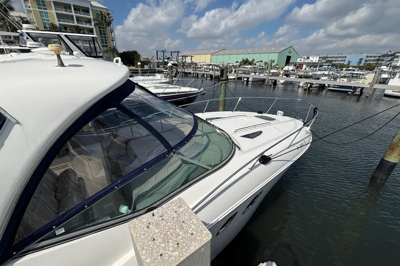 Slide: The Image of 2009 Sea Ray Sundancer 310 docked at a marina under a partly cloudy sky. - 7