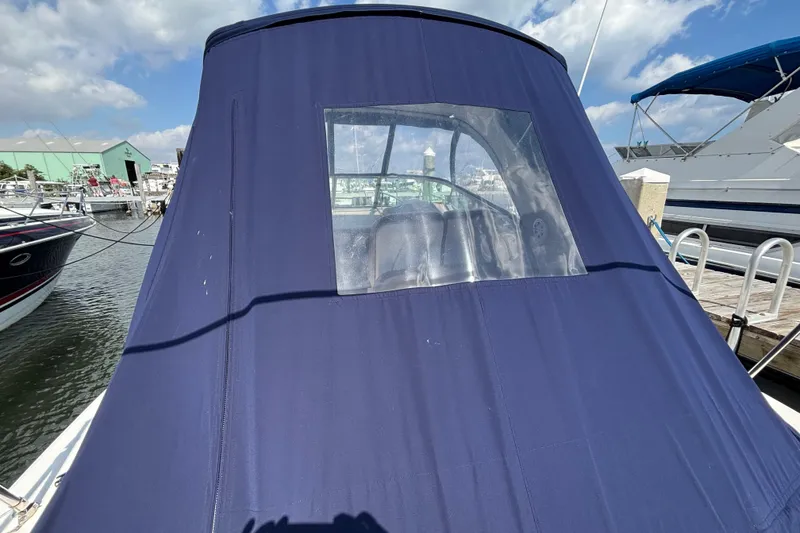 Slide: The Image of 2009 Sea Ray Sundancer 310 with blue canvas cover at marina dock. - 9