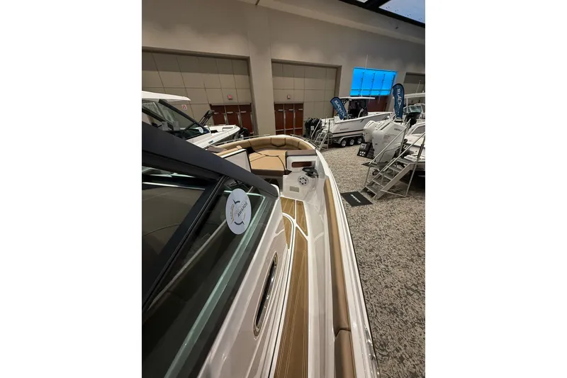 Slide: The Image of 2026 Monterey Elite 27 OB boat displayed indoors at a showroom event. - 10