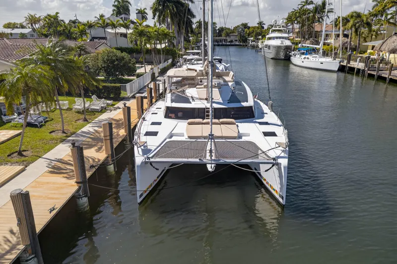 Slide: The Image of 2022 Fountaine Pajot Tanna 47 catamaran docked in a scenic marina. - 11