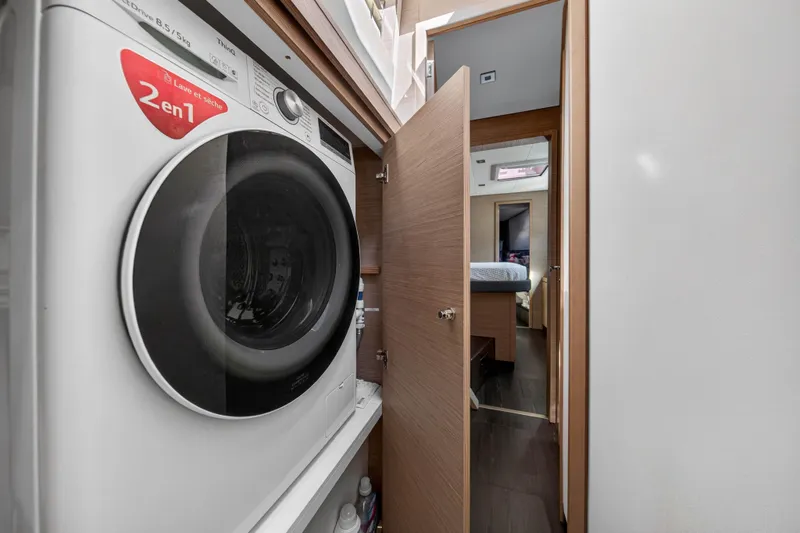 Slide: The Image of Laundry area inside 2022 Fountaine Pajot Tanna 47 yacht, featuring a modern washer-dryer. - 114